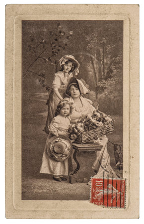 PARIS, FRANCE - CIRCA 1900: Old photo postcard of mother with daughter in vintage dress