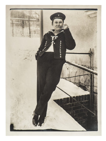 BERLIN, GERMANY - CIRCA 1928: Portrait of young smoking woman wearing marine suit. Vintage picture...