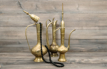 Vintage arabic jug, vase, teapot. Golden oriental decorations and islamic rosary beads