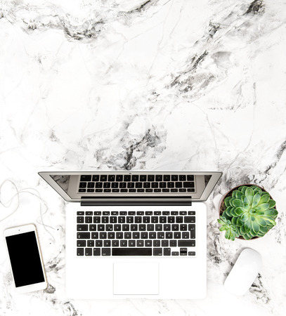 Laptop, phone, succulent plants on marble background. Working desk. Flat layの写真素材