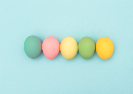 Easter eggs on blue background. Colorful holidays bannerの写真素材