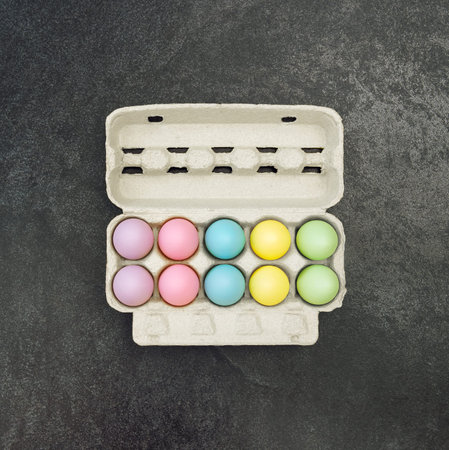 Easter eggs in egg box on black background