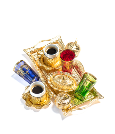 Oriental hospitality. Golden coffee cups and color tea glasses on white backgroundの写真素材