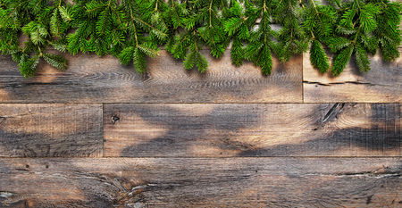 Christmas tree branches on rustic wooden background. Undecorated evergreen twigsの写真素材