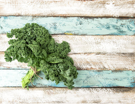 Kale cabbage. Green vegetable leaves on rustic wooden background. Organic foodの写真素材