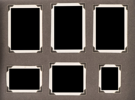 Old photo album page with corners on dark background. Used paper texture