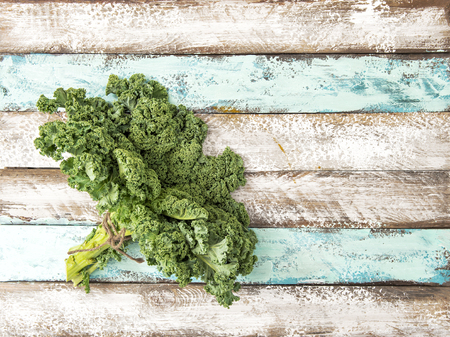 Kale cabbage. Green vegetable leaves on rustic wooden background. Organic foodの写真素材