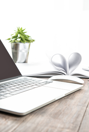 Office workplace with laptop, notebook, heart, succulent. Selective focusの写真素材