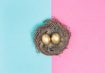 Golden Easter eggs in birds nest. Flat lay pink blueの写真素材