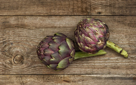 Artichoke vegetable on rustic wooden background. Raw food ingredients