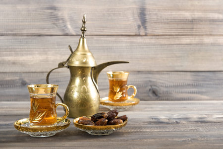Tea table with golden oriental decoration on rustic wooden background
