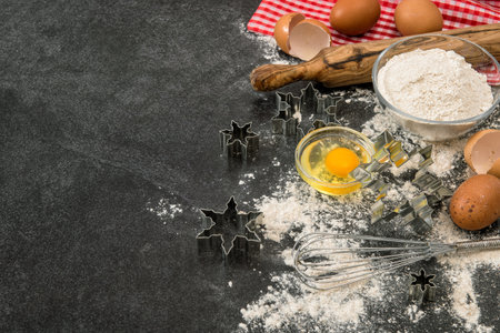 Baking ingredients and tolls. Flour, eggs, rolling pin and cookie cutters. Christmas food