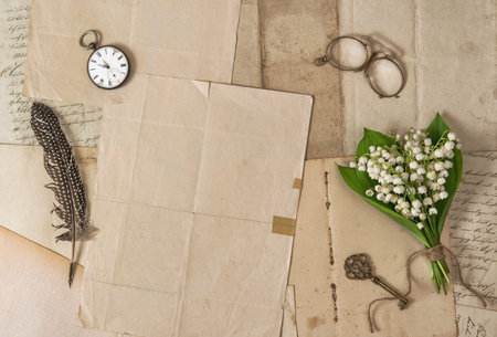 Old paper, feather pen, vintage accessories and spring flowers. Nostalgic background