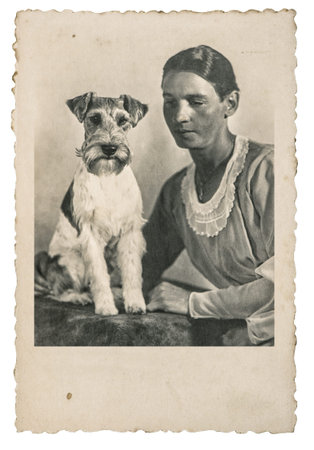 Portrait of young dreamy woman with cute dog. Vintage picture circa 1930 with original film grain and blurのeditorial素材