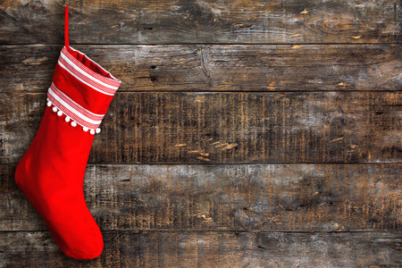 Red Christmas stocking on wooden background. Rustic weathered surfaceの写真素材