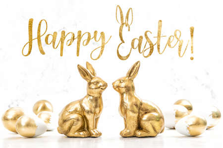 Happy Easter! Golden bunnies with Easter eggs decorationの写真素材