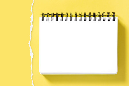 Spiral notepad book mockup and torn paper border for presentation of your design. Yellow background
