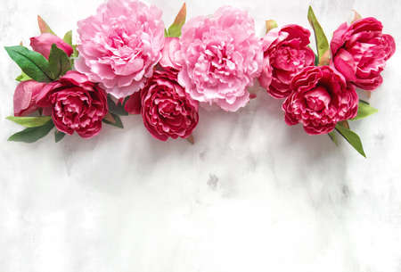 Pink peony flowers bouquet on marble texture. Floral backgroundの写真素材
