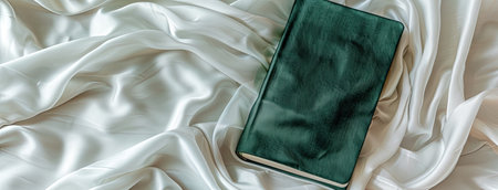 an emerald-covered diary set against a luxurious white cream silk background, exuding sophistication and styleの素材
