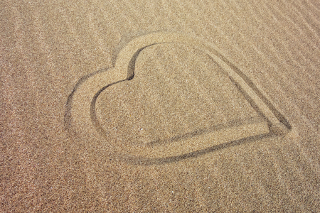 Heart drawn on the sandy beach on the seafrontの写真素材