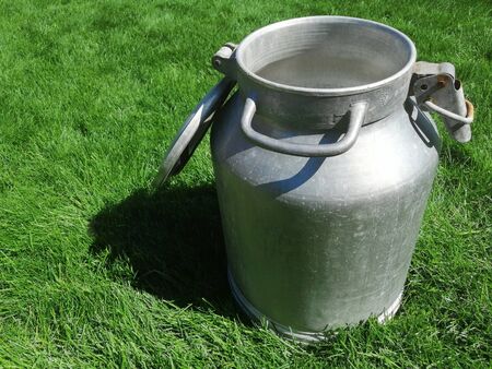 metal can for liquids with an open lid. in sunny weather on the grass. the idea of a healthy diet. close-upの写真素材