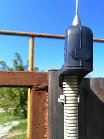 automatic gates. the idea is home safety. signal lamp and antenna for the gate. remote control. fences and protections for a private house. mechanism against a blue cloudless sky, bottom viewの写真素材
