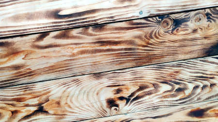 Wooden background. Texture of burned wood. Beautiful drawing on the surface of the boards.の写真素材