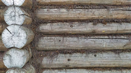 The wall of the house is made of wooden logs, extending into the distance. Horizontal background and tree texture. Construction of baths and houses.の写真素材