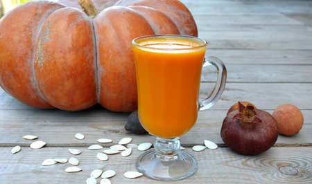 Pumpkin juice in a glass for a weight loss program. Autumn vitamin still life on a wooden background.の写真素材