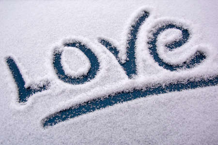 The word Love is written in the snow. Snow Declaration of love. Original love message in winter.の写真素材