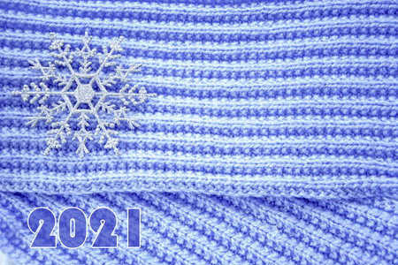 A huge snowflake. Christmas toys in the form of snowflakes lie on a hand-knitted lilac scarf. New...