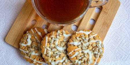 Cookies and a cup of tea for breakfast. View from above. Fragrant pastries with sunflower seeds next...