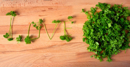 Love. The word love is laid out from parsley leaves. Greens on a cutting board.