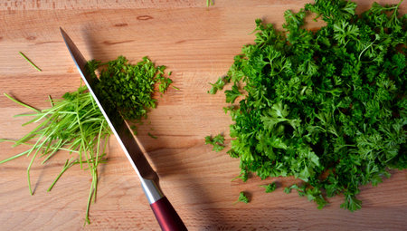 Greens on a cutting board. Finely chopped parsley for salad.の写真素材