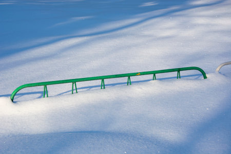 Barrage for an attraction with a snowdrift. She poured a lot of snow on the fence. Winter day in the city recreation park.の写真素材