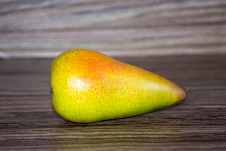 Pear close-up. Yellow long pear lies on a wooden background.の写真素材