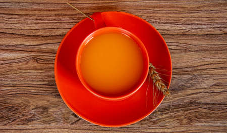 Cup with pumpkin juice and cereal on a wooden background. Halloween still life.の写真素材