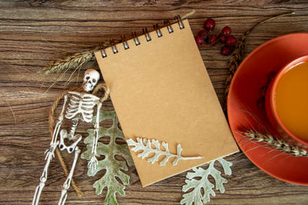 Blank notepad, pumpkin juice cup, skeleton, autumn leaves and cereals.の写真素材