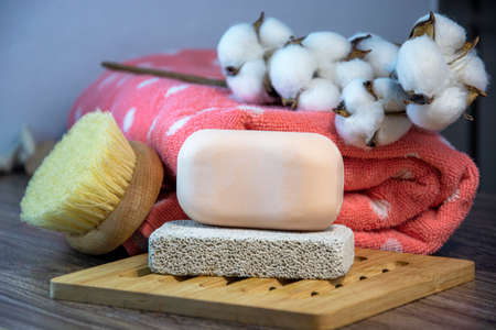 Hygiene supplies for bath and spa treatments on a wooden background. Cotton, natural body brush, towel, soap and pumice.の写真素材