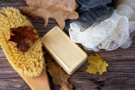 Spa supplies in autumn leaves. Towel, soap, brush, washcloth and cotton.の写真素材
