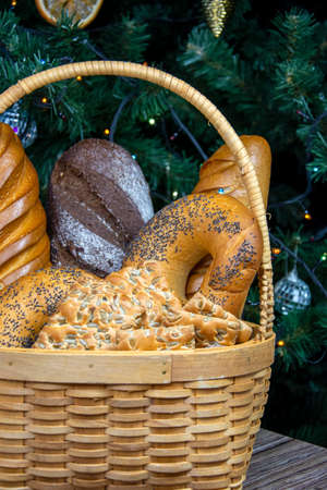 A basket of pastries stands near the Christmas tree. Fresh bread.の写真素材