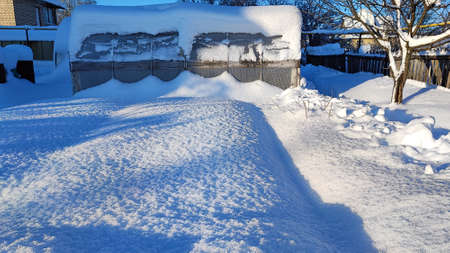 Greenhouse in winter. Reliable polycarbonate greenhouse in winter under snow. The greenhouse in the garden is covered with snow.の写真素材