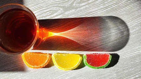 A glass of tea with refracted light and colored sugar marshmallowsの写真素材