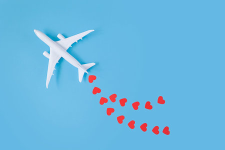 Happy Valentine's Day. model airplane on blue background with red hearts