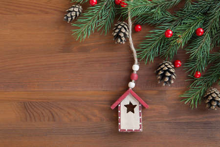 Christmas wooden toy house on red christmas background. Eco natural frame. Concept staying at home. Space for text.の写真素材