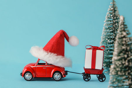Red car delivering christmas or new year gifts on a blue background. Christmas holiday celebration...