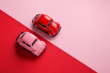 Kiev, Ukraine, October, 30,2020: Small color toy cars on red and pink background. Business Competition, Winner and Loser concept. Love concept. Concept for Competition. Envy conceptの写真素材