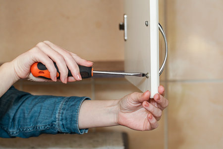 Woman Repairing Furniture with screwdriver at home. Repair home concept.