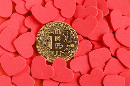 Coin crypto currency, red hearts on red background. Concept of donorship, life saving or charity. Close-up shotの写真素材