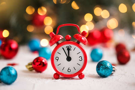 Alarm clock and red, blue christmas toys on white table.の写真素材